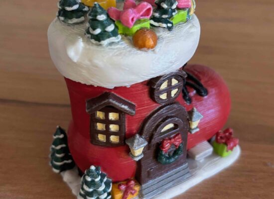 Ein Haus, welches ein Nikolausschuh ist. mit Geschenken drum herum und darauf