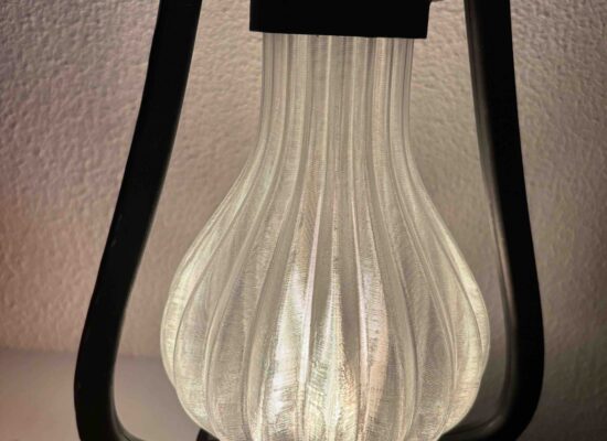 Eine Lampe mit schwarzem Griff und milchigem Glas. Sieht aus wie früher die Handlampen
