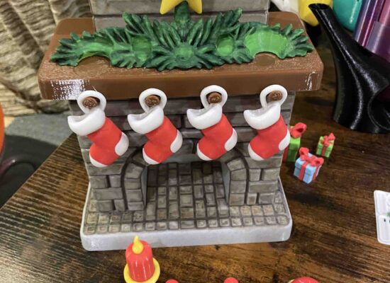 ein Weihnachtskamin mit Strümpfen, Kerze, Grünzeug, Stern, schön handbemalt