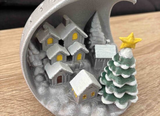 Winterdeko: ein verschneites Dorf in einer halben Kugel