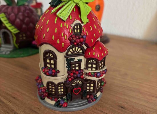 Ein Haus mit Erdbeer-Dach und vielen Beeren an allen Fenstern.